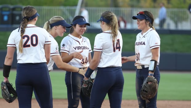 Eden Bigham celebrates with her teammates in the pitcher's circle during the Virginia softball game against JMU at Palmer Park.
